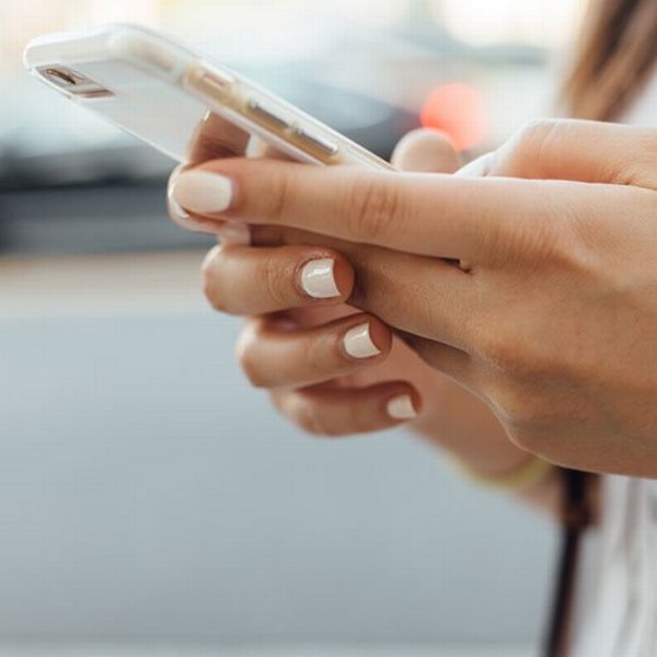 somfy-hands-lady-holding-smartphone-white-nails